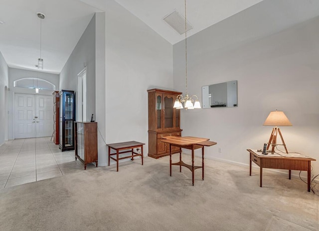 interior space featuring light carpet, baseboards, and high vaulted ceiling