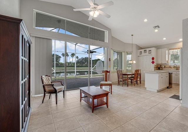 living area featuring light tile patterned floors, ceiling fan, visible vents, and high vaulted ceiling