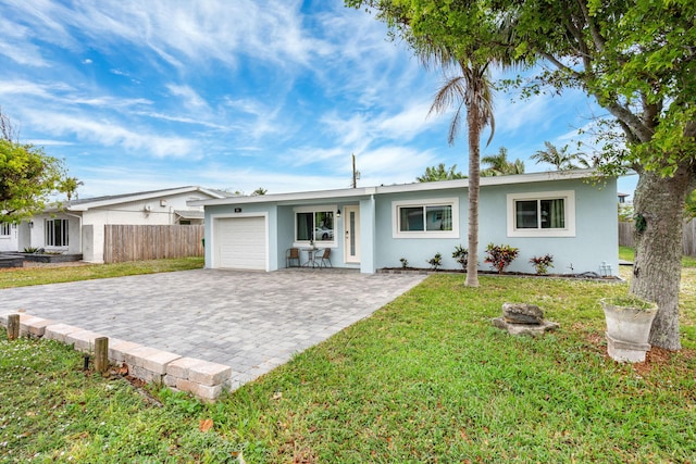 single story home with a garage, decorative driveway, fence, and stucco siding