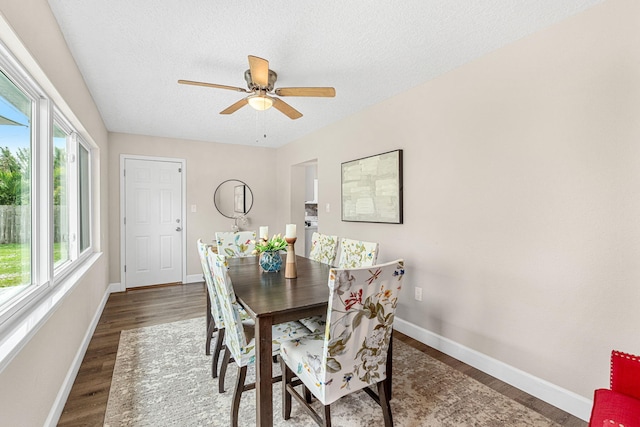 dining area featuring a textured ceiling, wood finished floors, a ceiling fan, and baseboards