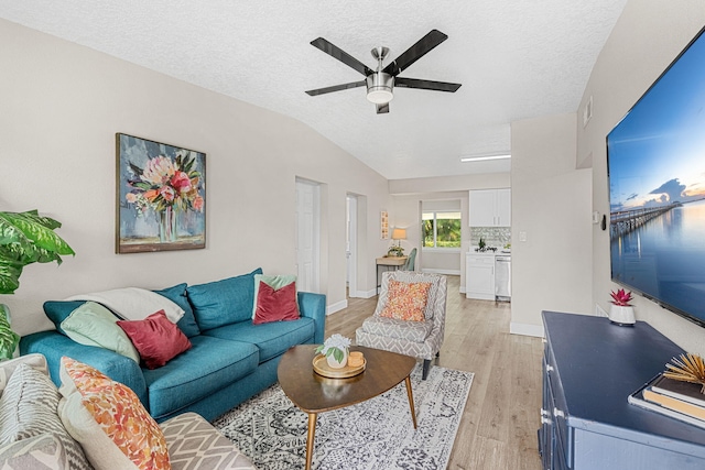 living room featuring vaulted ceiling, a textured ceiling, light wood-type flooring, and a ceiling fan