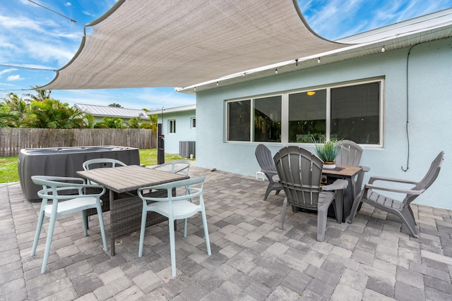 view of patio with outdoor dining space, fence, and central air condition unit