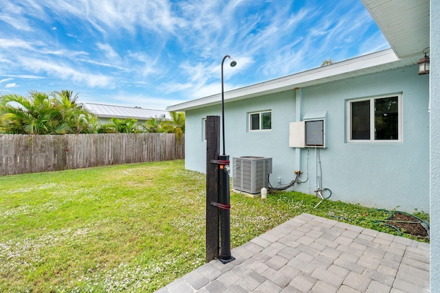 view of yard featuring central AC unit, a patio area, and fence