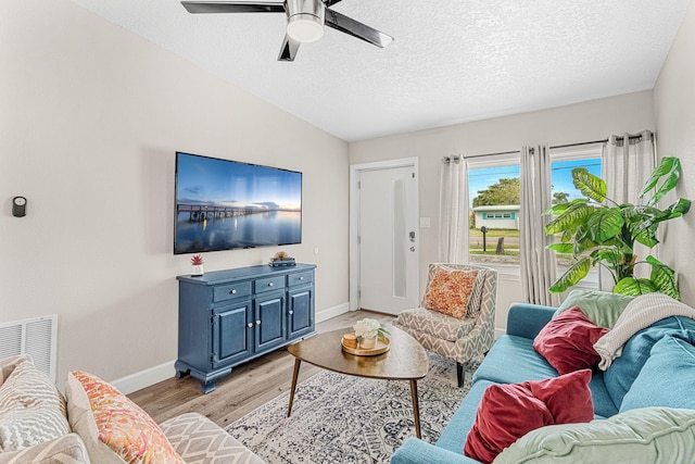 living room featuring visible vents, ceiling fan, a textured ceiling, light wood-type flooring, and baseboards