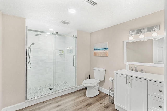 full bath featuring toilet, a stall shower, wood finished floors, and visible vents