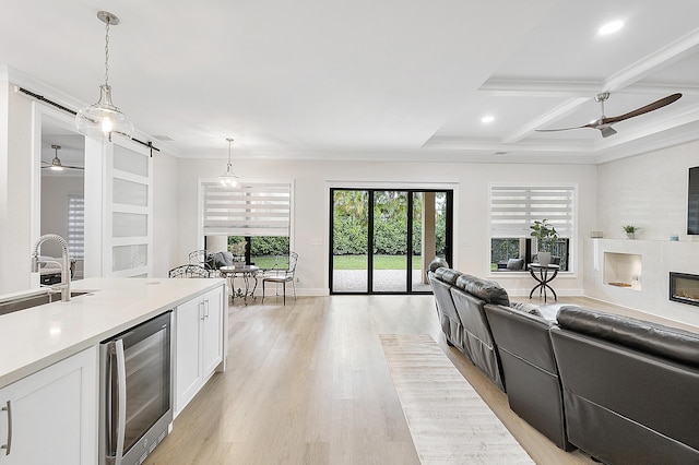 kitchen featuring a glass covered fireplace, open floor plan, white cabinetry, a barn door, and wine cooler