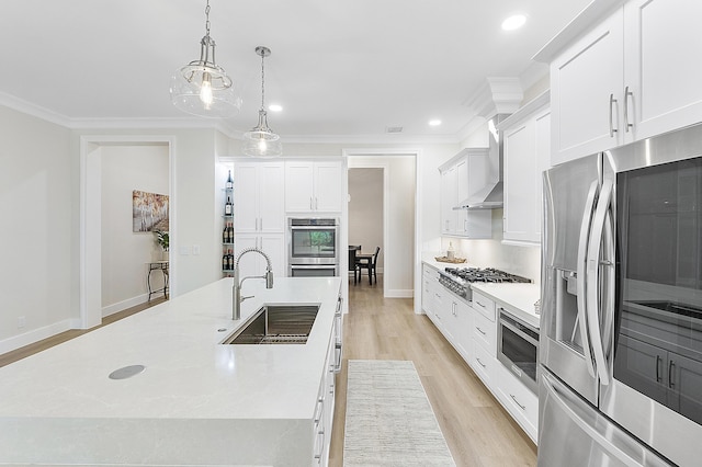 kitchen featuring a sink, stainless steel appliances, crown molding, and wall chimney range hood