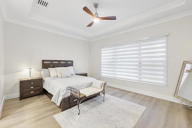 bedroom featuring crown molding, light wood-style floors, and visible vents