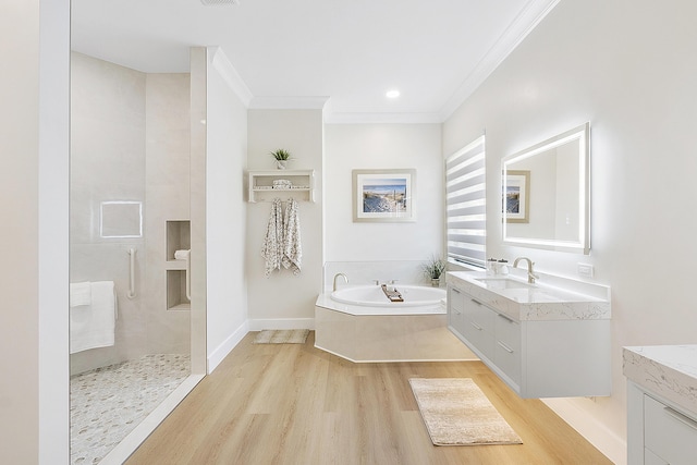 full bathroom featuring crown molding, walk in shower, two vanities, wood finished floors, and a bath