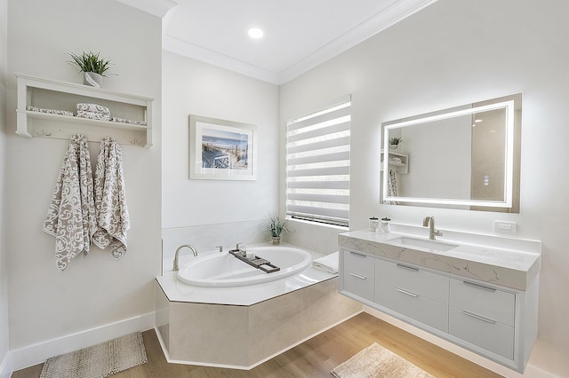 full bathroom with crown molding, baseboards, a garden tub, wood finished floors, and vanity