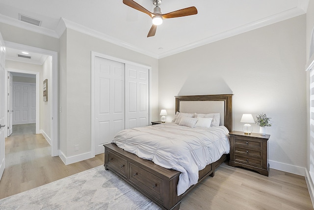 bedroom featuring a closet, visible vents, crown molding, and light wood-style floors