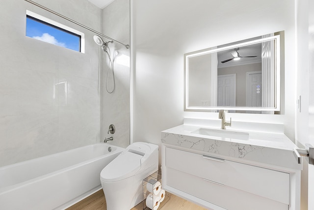 bathroom with toilet, wood finished floors, shower / washtub combination, ceiling fan, and vanity