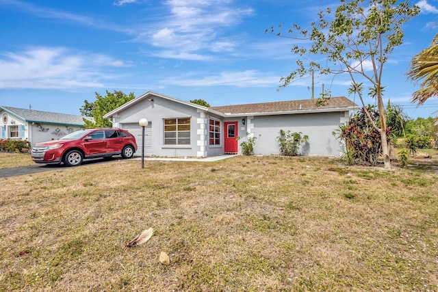 ranch-style home with a front lawn and stucco siding