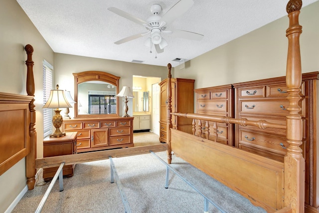 bedroom with visible vents, a textured ceiling, ensuite bath, and carpet flooring