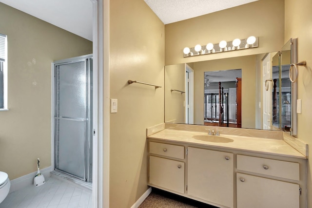 bathroom featuring vanity, toilet, baseboards, and a stall shower