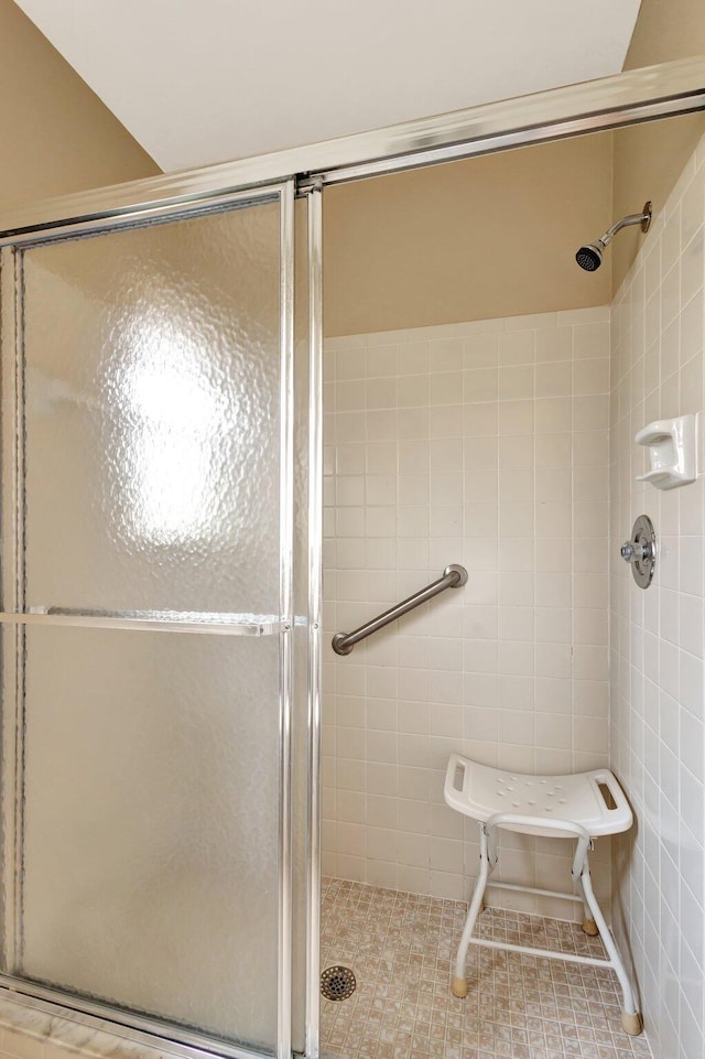 bathroom featuring a shower stall and tile walls