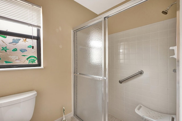 bathroom featuring toilet and a stall shower