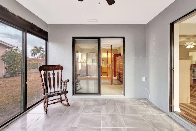 sunroom / solarium featuring ceiling fan