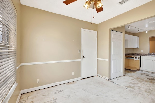 interior space featuring visible vents, baseboards, track lighting, and a ceiling fan