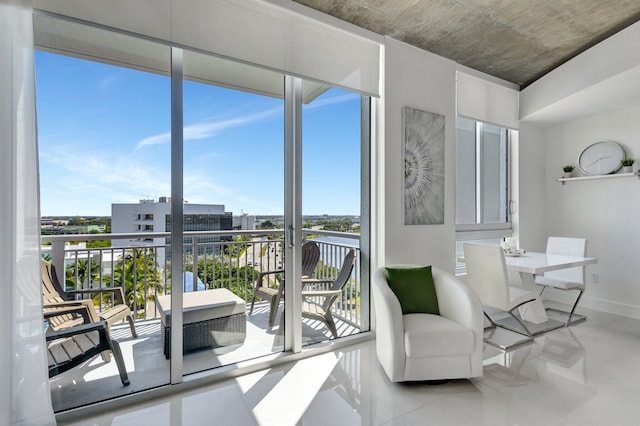 interior space featuring a wealth of natural light, a city view, and baseboards