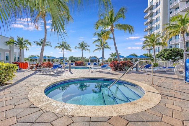 community pool with a patio and a community hot tub