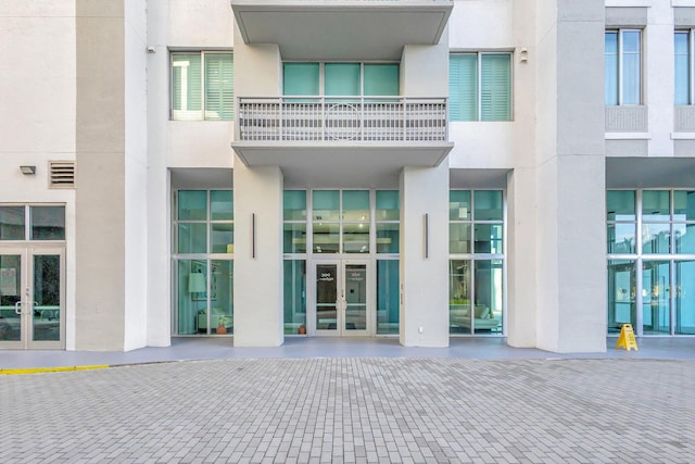 entrance to property featuring french doors and stucco siding