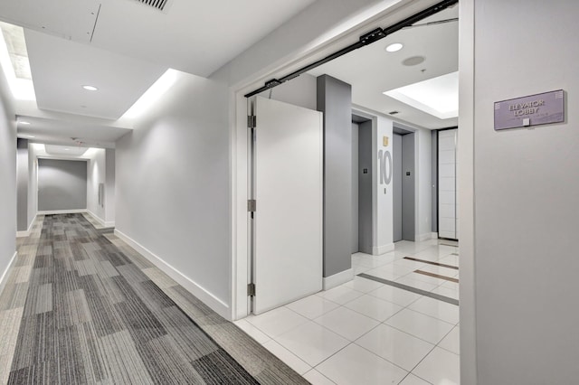 corridor with light tile patterned floors, recessed lighting, baseboards, and elevator