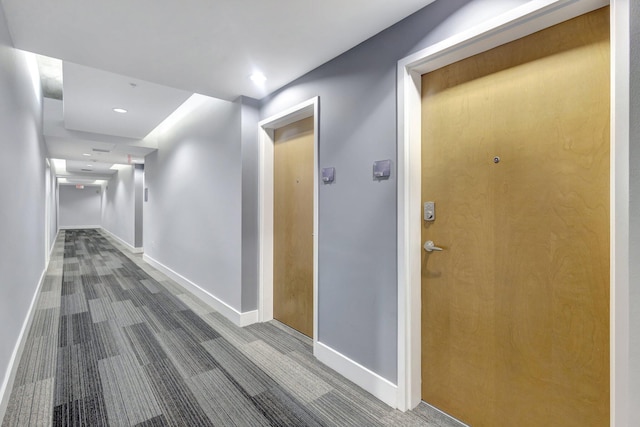 hallway with recessed lighting and baseboards