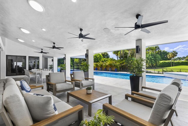 view of pool with a patio area, fence, and a pool with connected hot tub