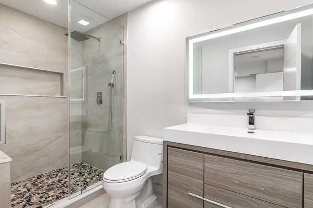 full bathroom featuring toilet, a stall shower, tile patterned flooring, baseboards, and vanity