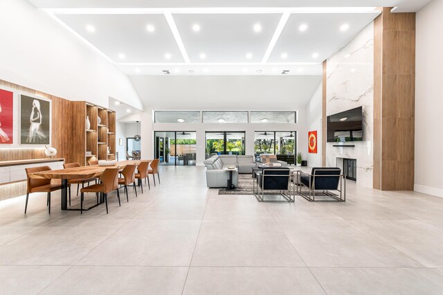 dining space with recessed lighting, baseboards, and a towering ceiling