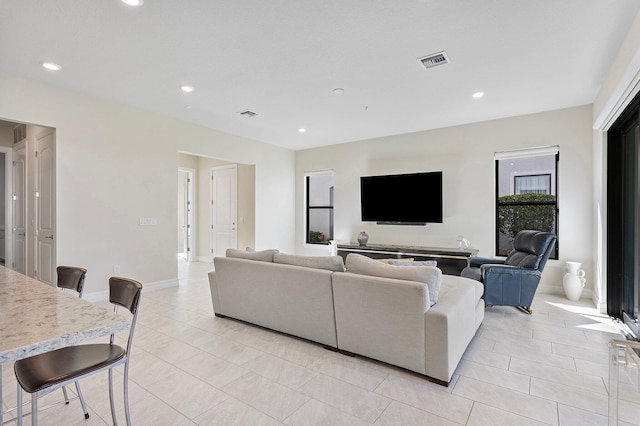 living room with recessed lighting, light tile patterned flooring, and visible vents