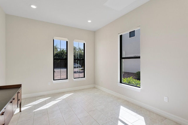 spare room with baseboards, a wealth of natural light, recessed lighting, and light tile patterned flooring