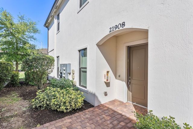 view of exterior entry featuring stucco siding