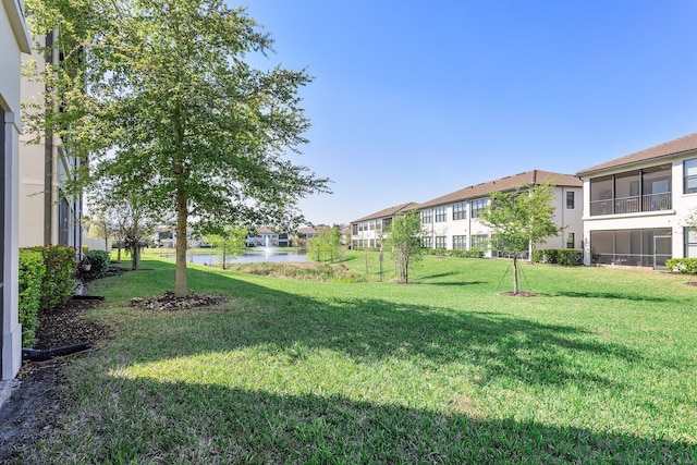 view of yard featuring a residential view and a water view