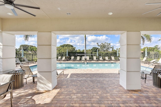 community pool with fence, ceiling fan, and a patio area