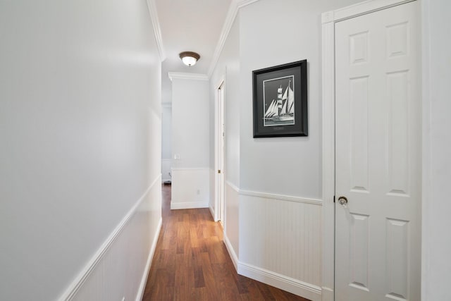 hall with a wainscoted wall, ornamental molding, and wood finished floors