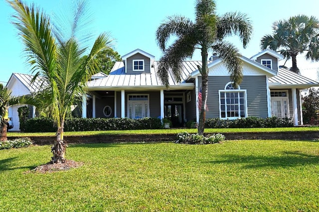 view of front facade featuring a standing seam roof, metal roof, and a front lawn