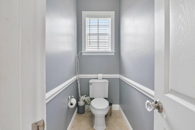 bathroom with tile patterned flooring, baseboards, and toilet