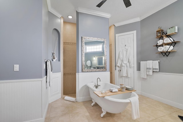 full bathroom with a walk in shower, a wainscoted wall, crown molding, and tile patterned floors