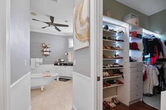 walk in closet featuring light tile patterned floors and a ceiling fan