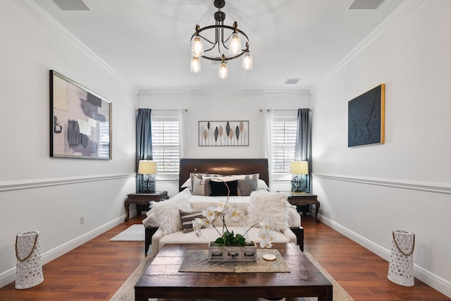 bedroom featuring baseboards, visible vents, wood finished floors, crown molding, and a notable chandelier