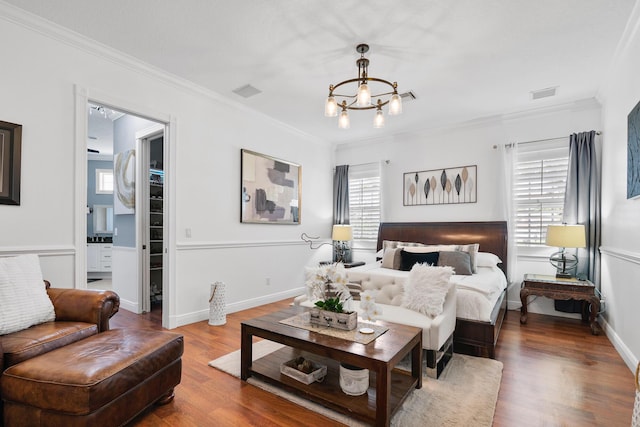 bedroom featuring multiple windows, visible vents, wood finished floors, and ornamental molding