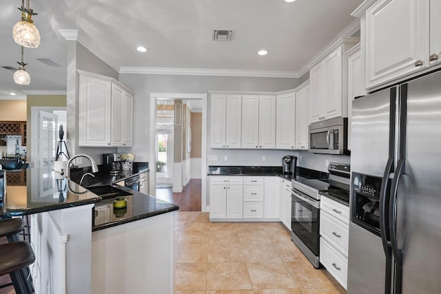 kitchen with visible vents, appliances with stainless steel finishes, white cabinets, a sink, and a peninsula