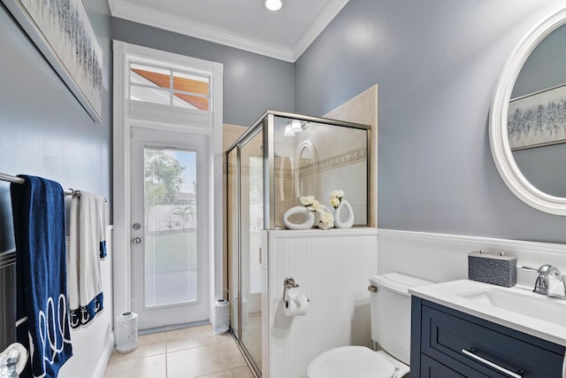 full bath featuring a wainscoted wall, ornamental molding, a shower stall, vanity, and tile patterned flooring