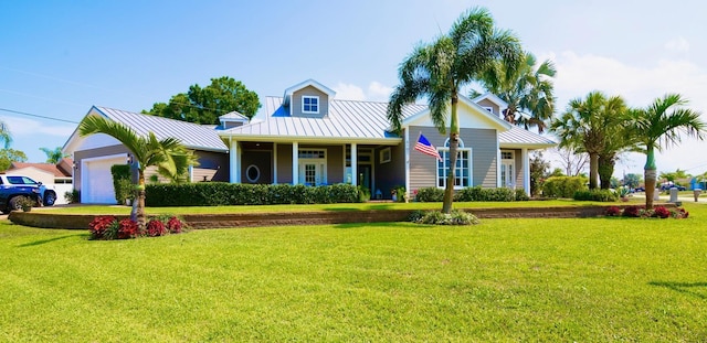 view of front of property with a garage, a standing seam roof, metal roof, and a front lawn