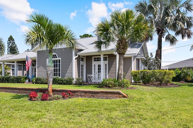 view of front of property with metal roof and a front yard