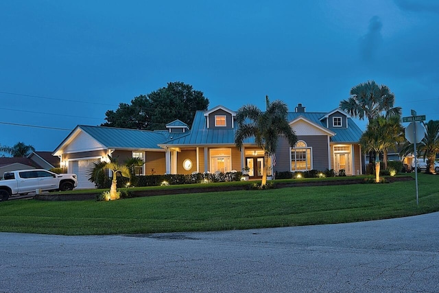 view of front of house featuring a chimney, metal roof, a standing seam roof, and a front yard