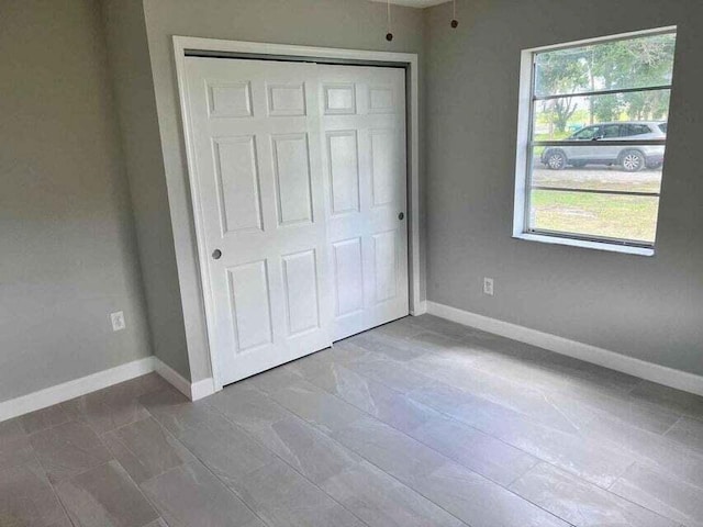 unfurnished bedroom with baseboards and a closet