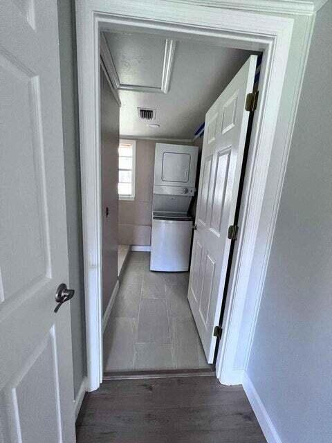 hallway featuring visible vents, light wood-style floors, attic access, and baseboards